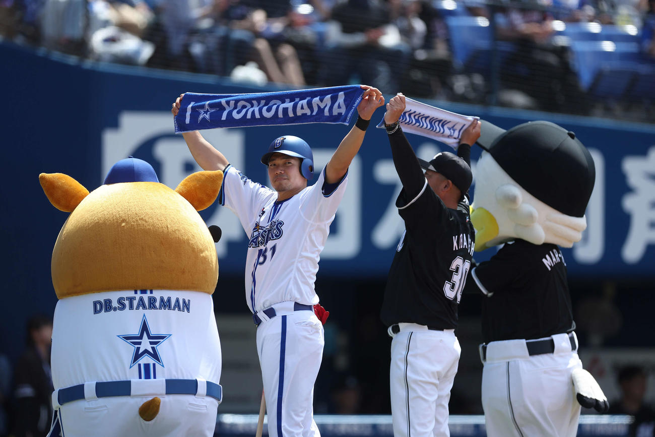DeNA対ロッテ　試合開始前、一打席対決を終え、タオルを掲げる吉村氏（左）と小林氏（撮影・河田真司）