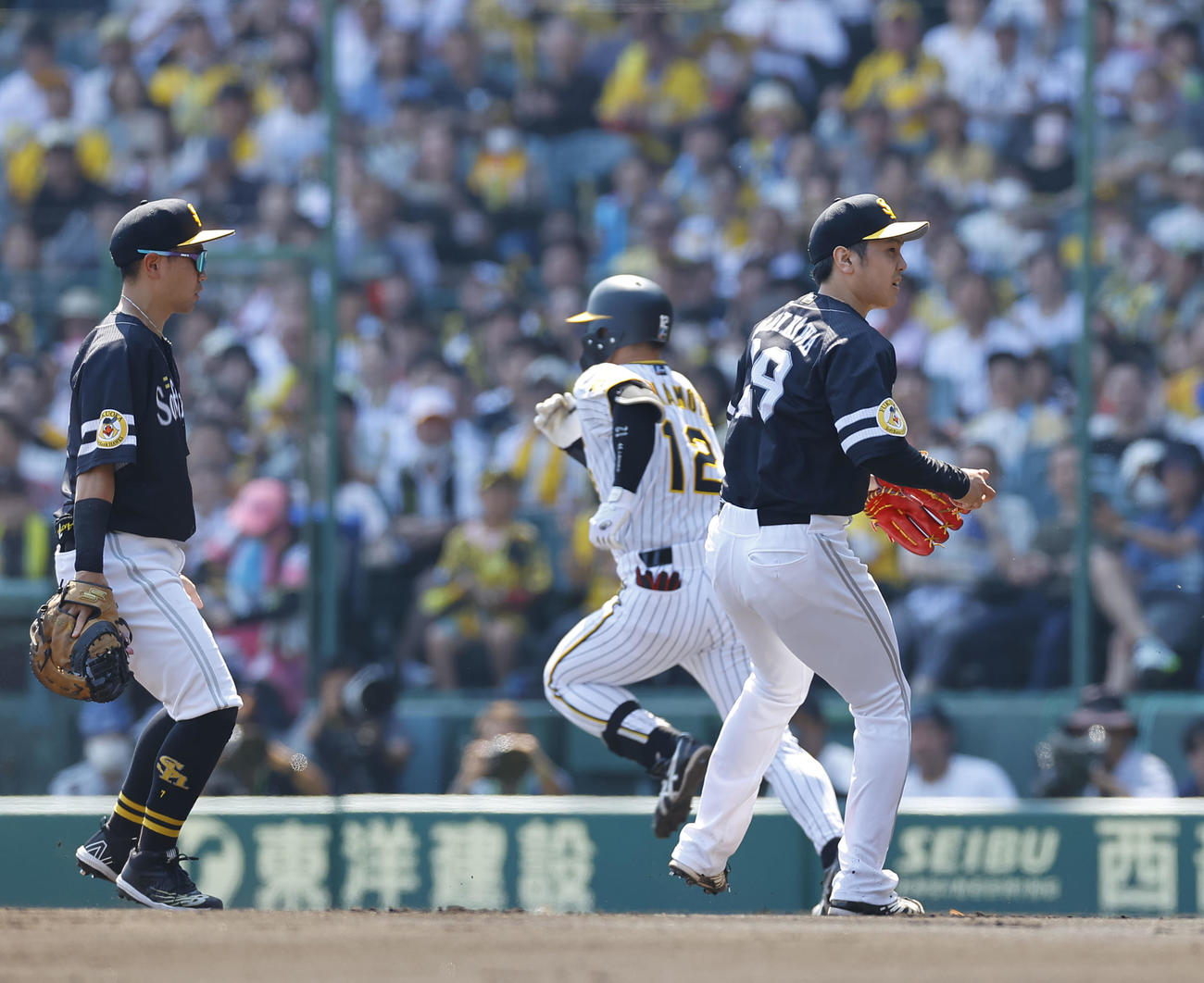阪神対ソフトバンク　2回裏阪神無死一、三塁、坂本の投前セーフティースクイズで、捕球後ホームを見るソフトバンク石川（右）（撮影・藤尾明華）