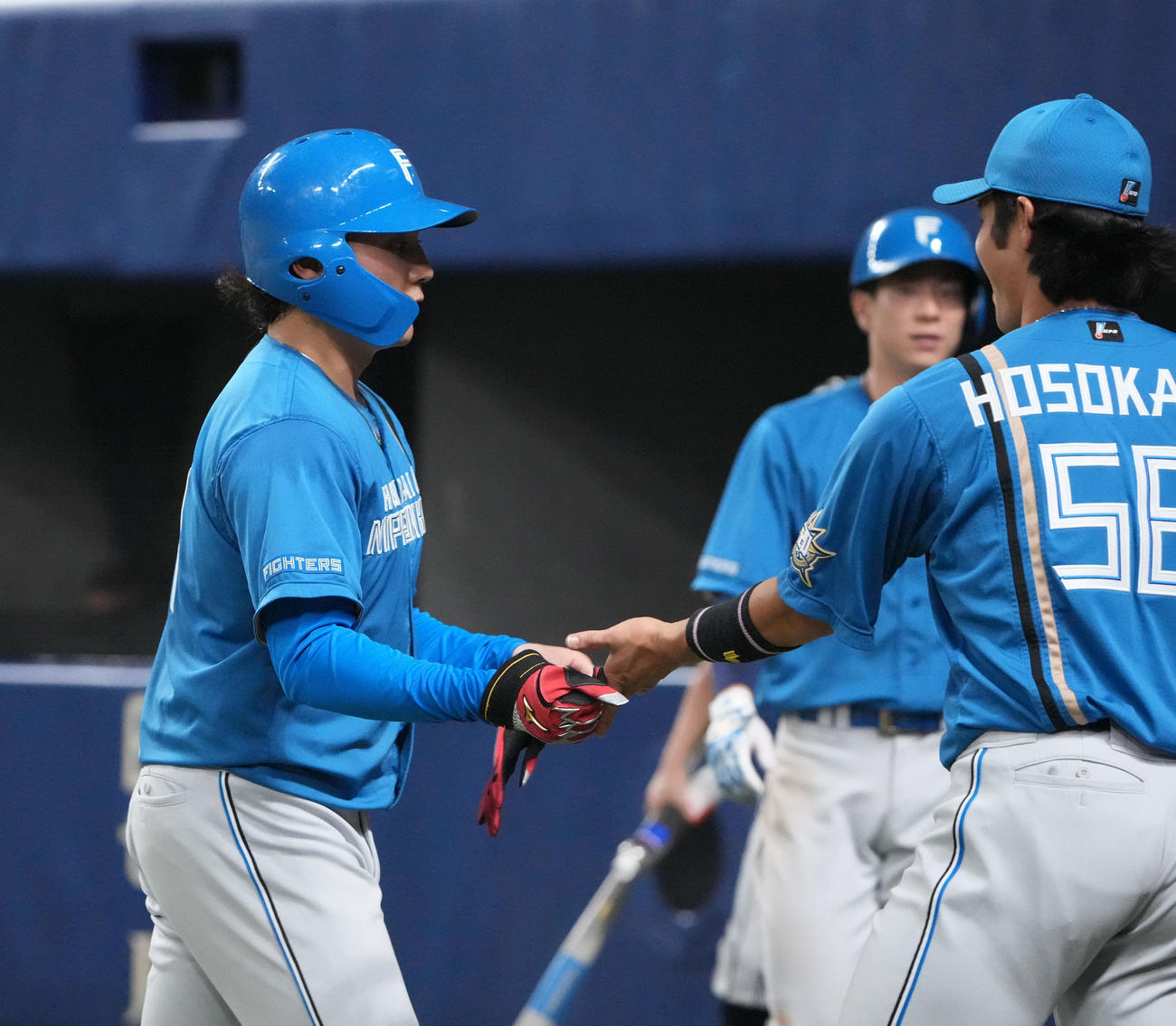中日対日本ハム　5回表終了、ベンチ前でタッチを交わす適時二塁打を放った伊藤（左）（撮影・森本幸一）