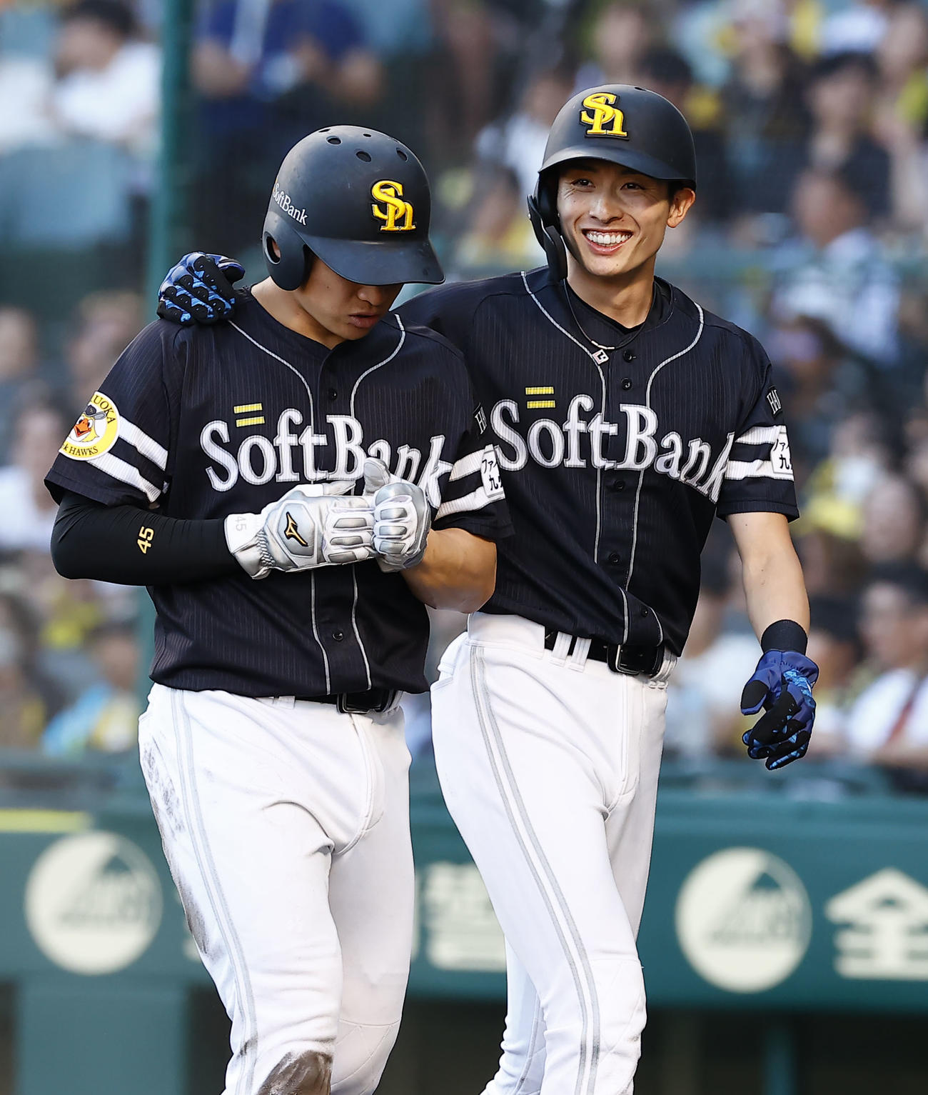 阪神対ソフトバンク　9回表ソフトバンク2死一、二塁、中村晃の左前2点適時打で生還し笑顔を見せる周東（右）と谷川原（撮影・藤尾明華）