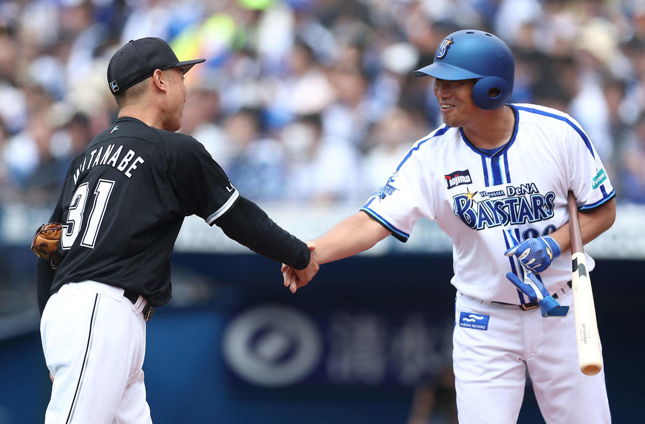 DeNA対ロッテ　試合前、一打席対決を終え握手を交わす臨む渡辺氏（左）と相川氏（撮影・河田真司）