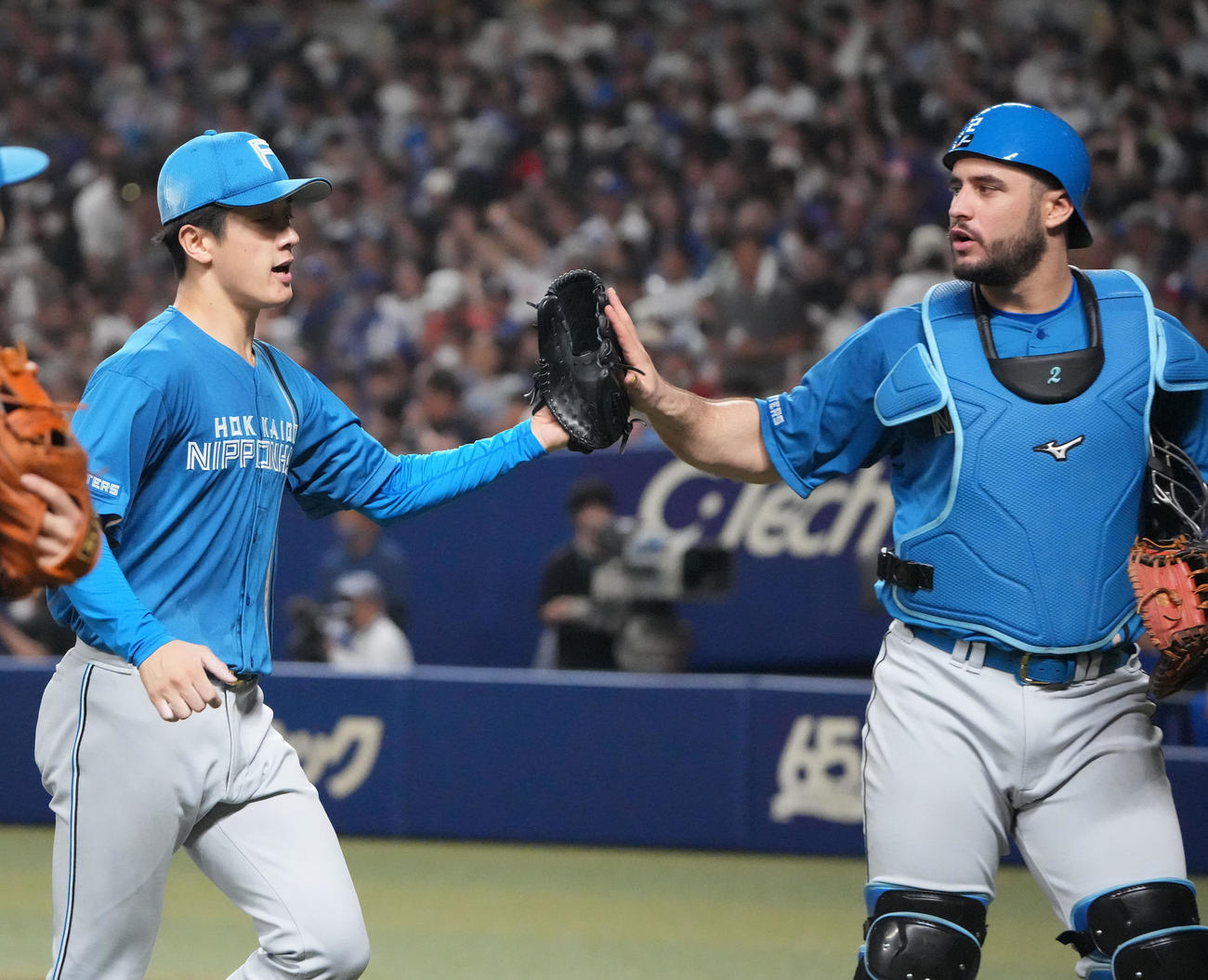 中日対日本ハム　6回終了、マルティネスとタッチを交わしベンチへ戻る北山（左）（撮影・森本幸一）