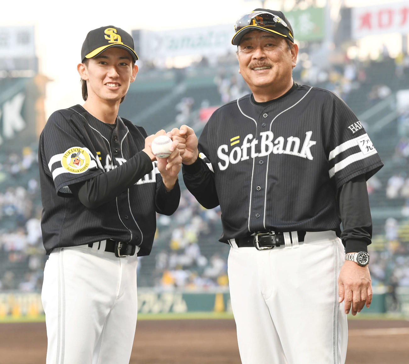 阪神対ソフトバンク　プロ初勝利のソフトバンク大津（左）は藤本監督の祝福に笑顔を見せる（撮影・前岡正明）