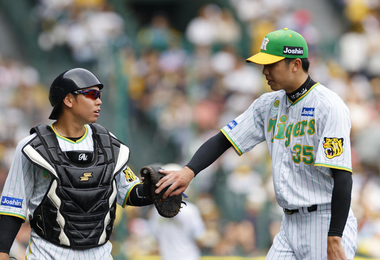 阪神対ソフトバンク　5回表を終え梅野（左）とタッチを交わす阪神才木（撮影・藤尾明華）