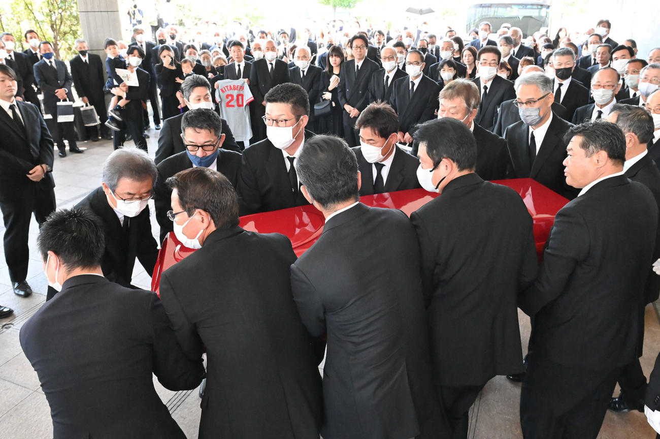北別府学氏告別式　真っ赤なひつぎを運ぶ手前左2人目から大野豊氏、緒方孝市氏、小早川毅彦氏、西山秀二氏。左奥から達川光男氏、野村謙二郎氏、佐々岡真司氏、前田智徳氏、長内孝氏、山根和夫氏