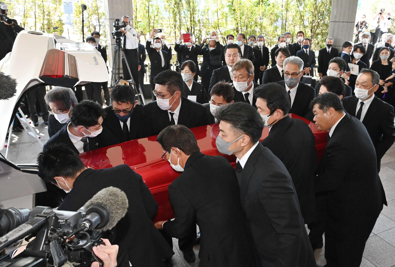北別府学氏告別式　真っ赤なひつぎを運ぶ手前左2人目から大野豊氏、緒方孝市氏、小早川毅彦氏、西山秀二氏、小林誠二氏。左奥から達川光男氏、1人おいて野村謙二郎氏、佐々岡真司氏、前田智徳氏、長内孝氏、山根和夫氏