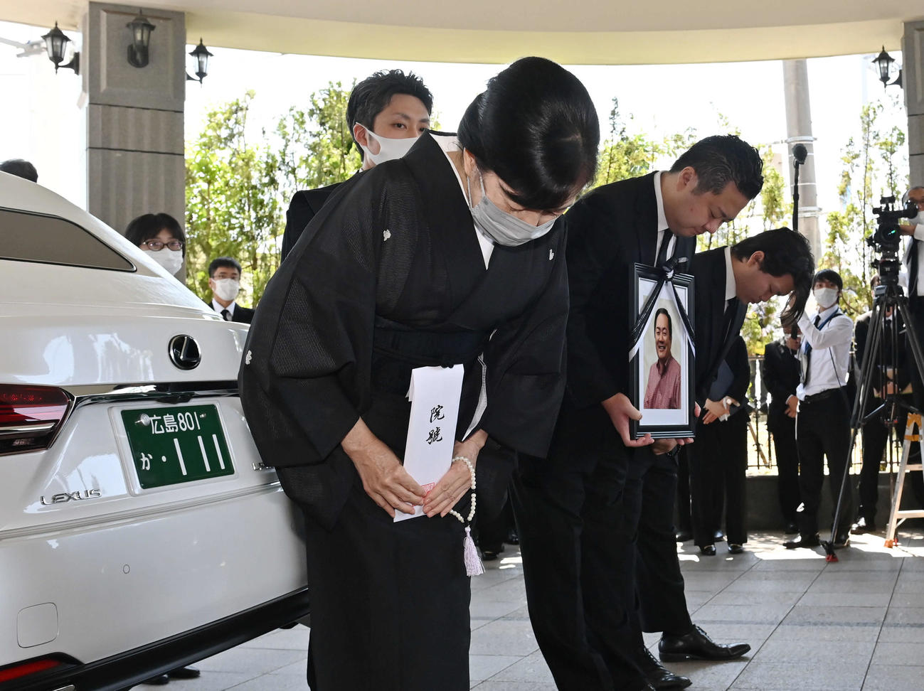 北別府学氏告別式　出棺　中央は妻の広美さん。右隣は遺影を持つ長男の大さん