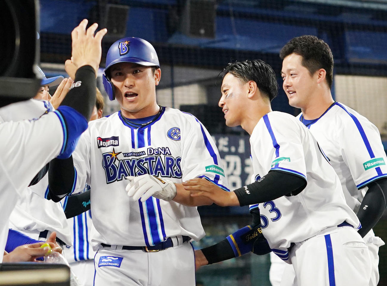 DeNA対日本ハム　6回裏DeNA2死満塁、大和の中前適時打で生還しナインとタッチを交わす佐野（左）（撮影・横山健太）