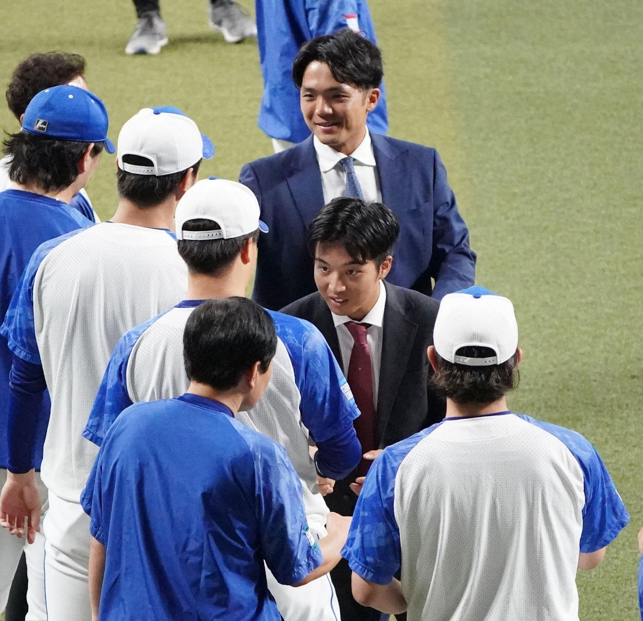 練習開始前、ナインにあいさつを行いタッチを交わす山本（右から2人目）と郡司（右から3人目）（撮影・森本幸一）