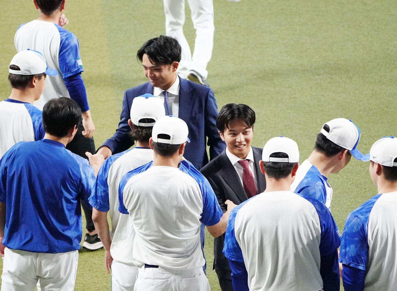 練習開始前、ナインにあいさつを行いタッチを交わす山本（右から4人目）と郡司（右から7人目）（撮影・森本幸一）