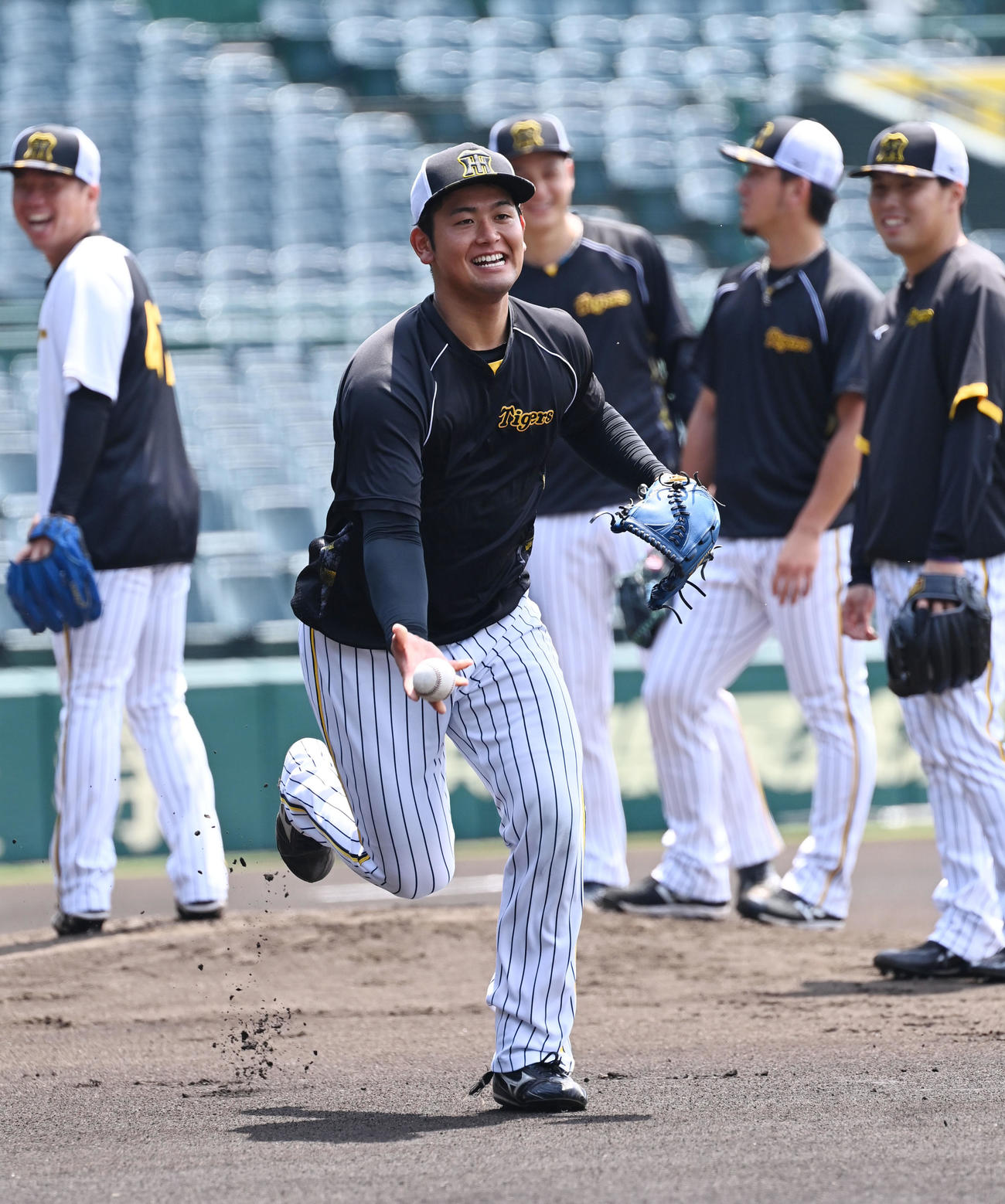笑顔で投内連携をする阪神岡留（撮影・和賀正仁）