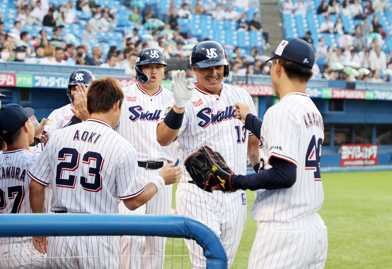 ヤクルト対楽天　1回裏ヤクルト2死一、二塁、オスナ（右から2人目）は左越え3点本塁打を放ちベンチ前で笑顔を見せる（撮影・鈴木正人）