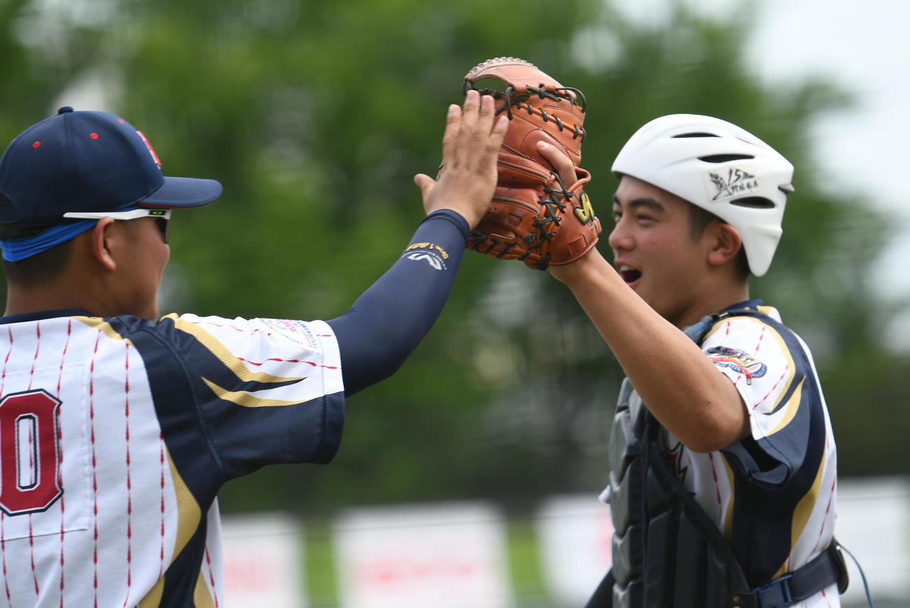 日本対フィリピン　ピンチを脱してベンチ前でハイタッチする豊永飛輝（右）と蔵並虎之介主将