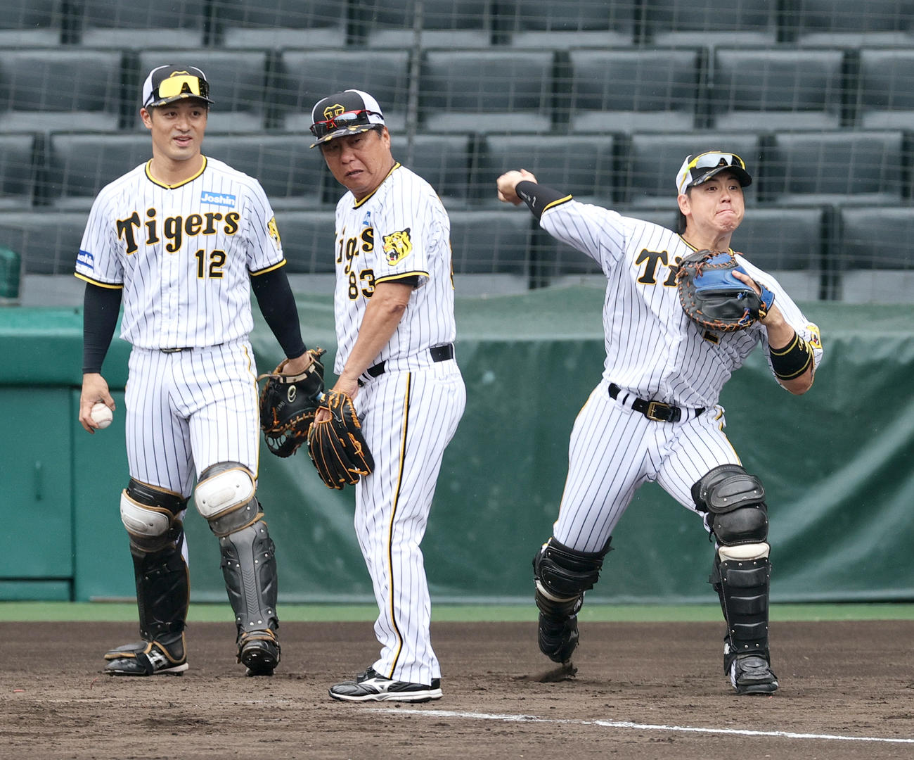 シートノックで送球する阪神梅野（右）。左は坂本（撮影・上山淳一）