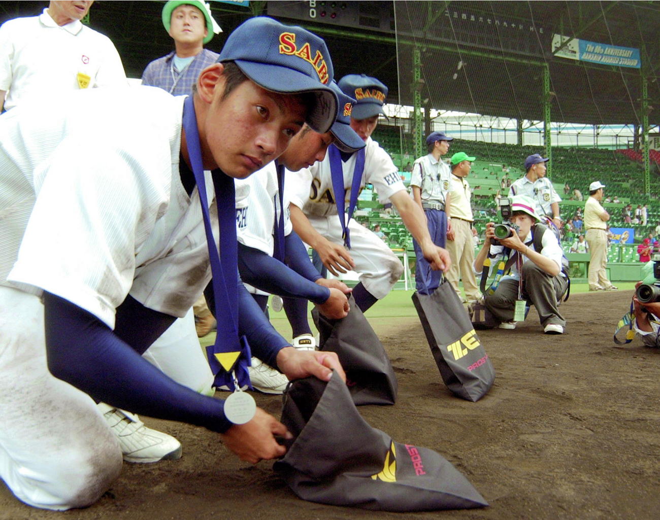 第86回全国高校野球選手権大会・決勝　駒大苫小牧対済美　優勝を逃し、甲子園の土を集める済美の鵜久森淳志（手前）ら選手たち（2004年8月22日撮影）