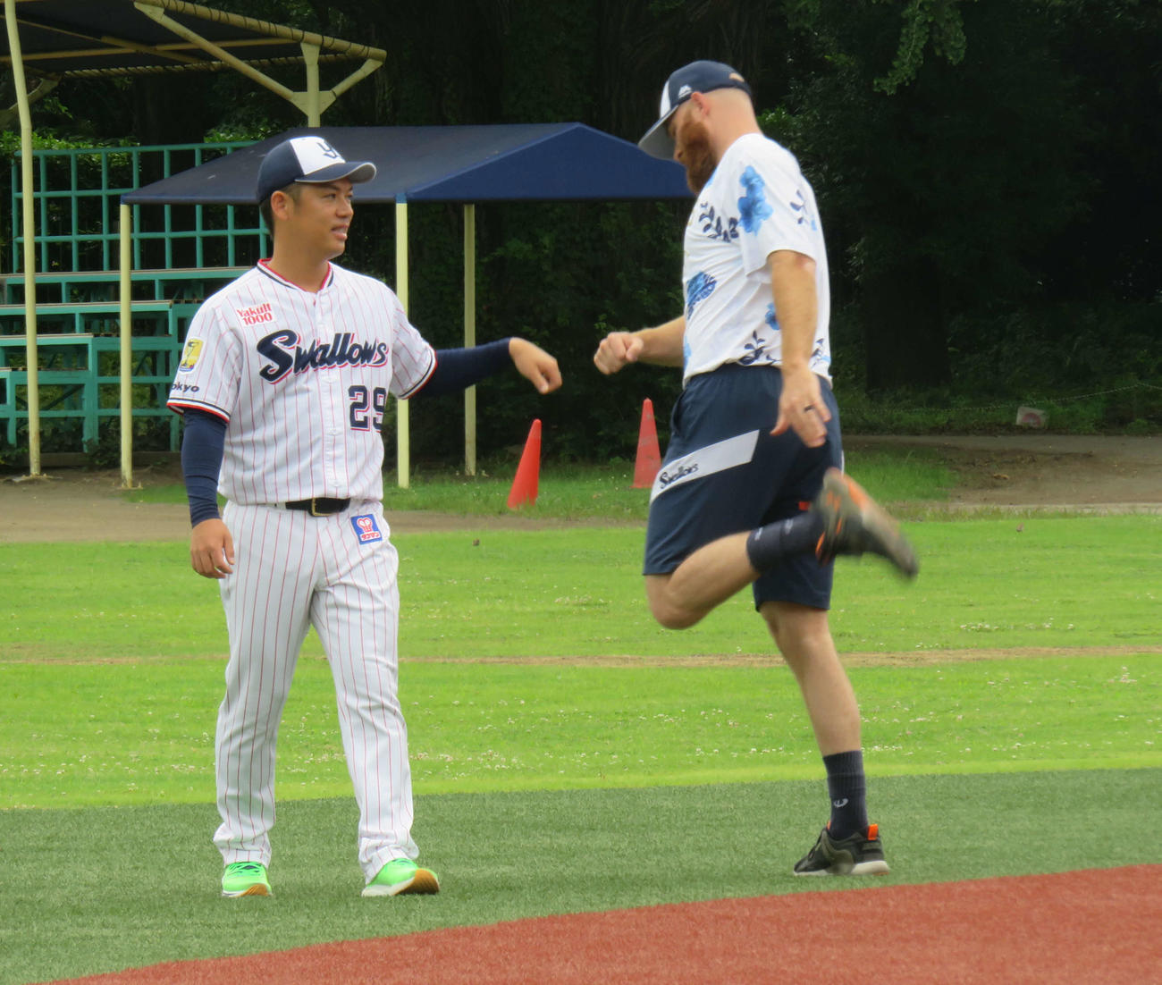 ウオーミングアップでグータッチするヤクルト小川（左）とサイスニード