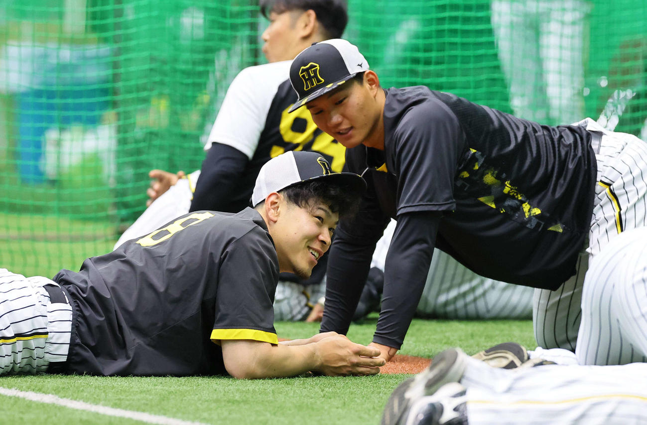 室内練習場で笑顔を見せる佐藤輝。右は森下（撮影・上田博志）