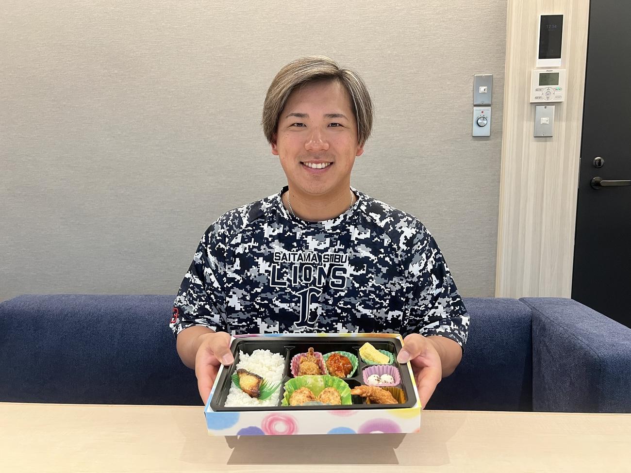 初プロデュースする球場グルメ「愛斗弁当」を手に笑顔を見せる西武愛斗（球団提供）