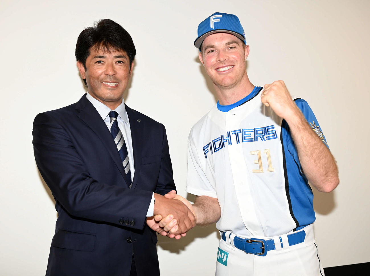 稲葉篤紀GM（左）と笑顔で握手を交わす日本ハムの新外国人マーベル（撮影・たえ見朱実）