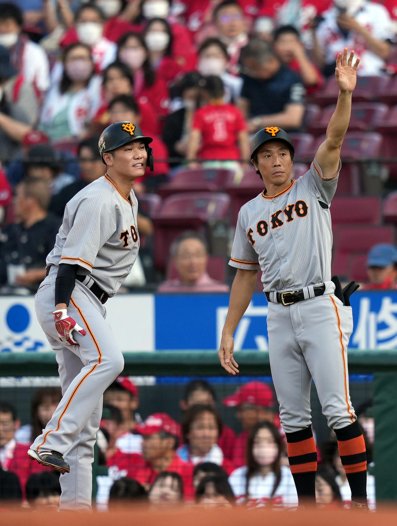広島対巨人　1回表巨人無死、内野安打を放った後、、右太ももを痛め、負傷交代する坂本（左）。右は鈴木外野守備兼走塁コーチ（撮影・狩俣裕三）