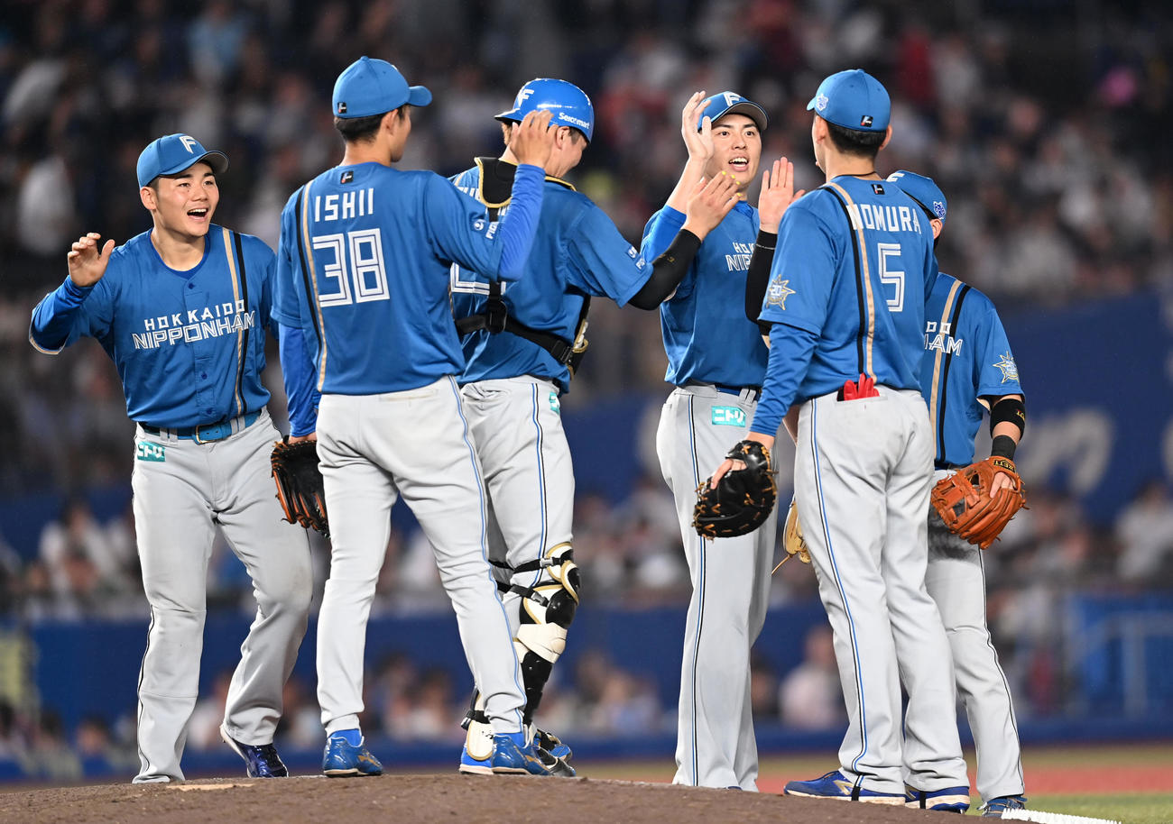 ロッテ対日本ハム　ロッテに勝利しタッチを交わす日本ハムナイン（撮影・横山健太）