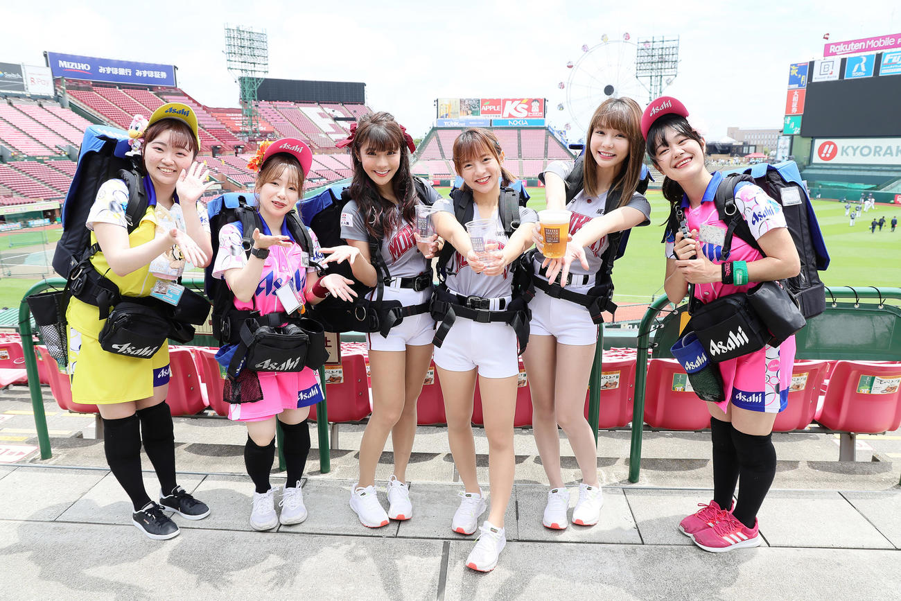 試合前、球場のビール販売スタッフと笑顔を見せる楽天モンキーズのチアリーダー「Rakuten Girls」の、中央左から琳妲（リンダ）、十元（ヒメ）、YURI（ユリ）（撮影・足立雅史）