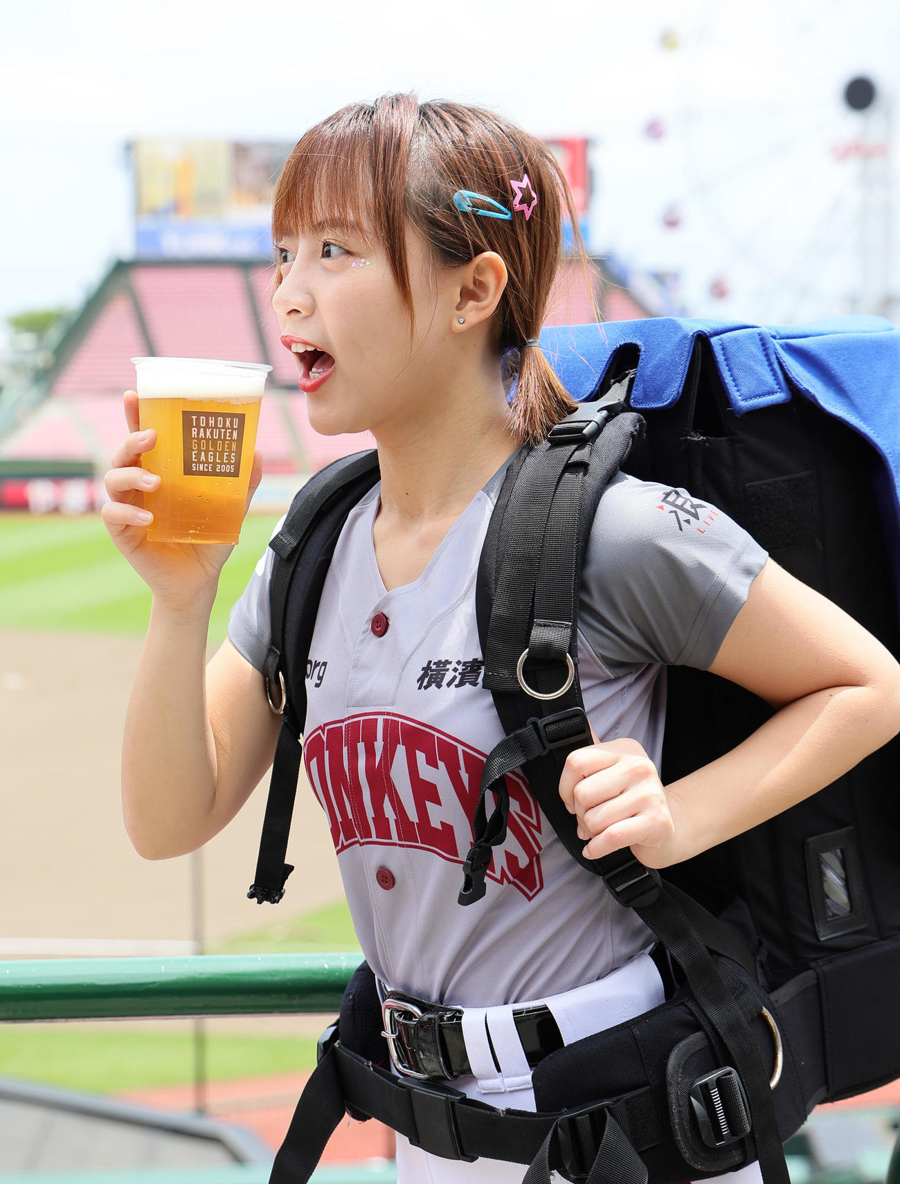 試合前、球場のビール販売スタッフ姿でポーズを決める楽天モンキーズのチアリーダー「Rakuten Girls」の十元（ヒメ）（撮影・足立雅史）
