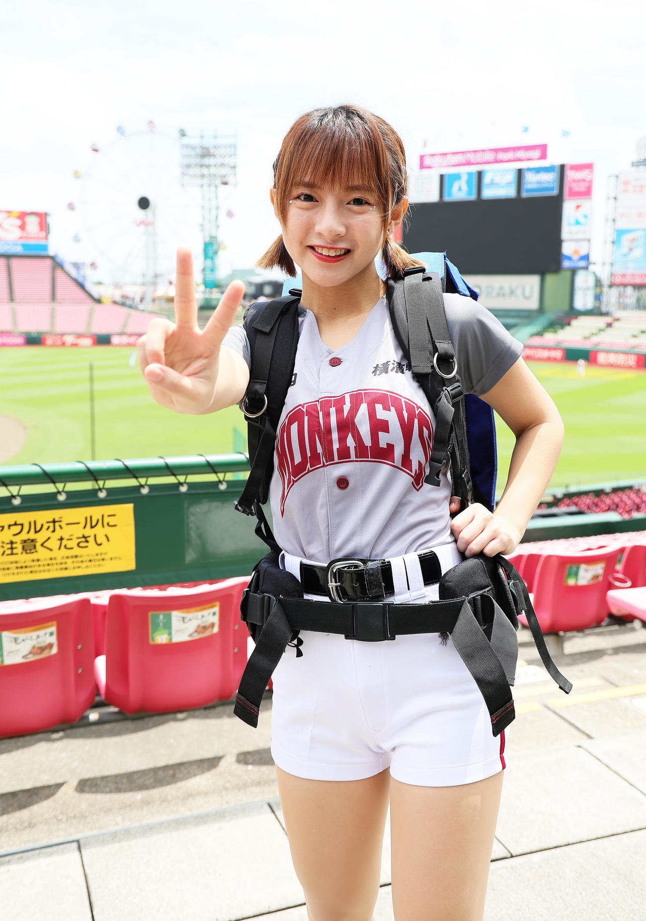 試合前、球場のビール販売スタッフ姿でポーズを決める楽天モンキーズのチアリーダー「Rakuten Girls」の十元（ヒメ）（撮影・足立雅史）