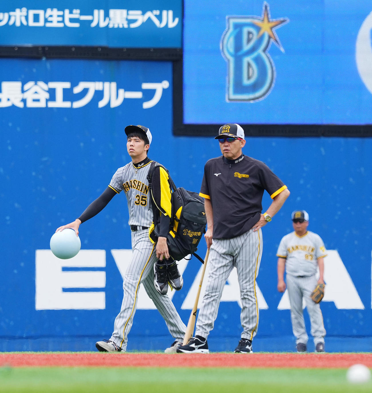 DeNA対阪神　試合前練習を終え引き揚げる阪神才木（左）。右は岡田監督（撮影・垰建太）