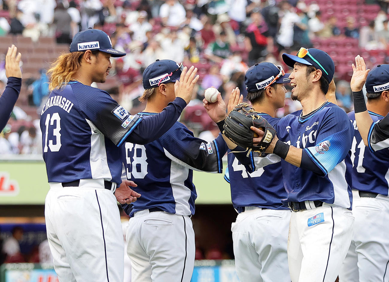 楽天対西武　8回無失点の西武高橋（左）は外崎から勝利球を受け取る（撮影・足立雅史）