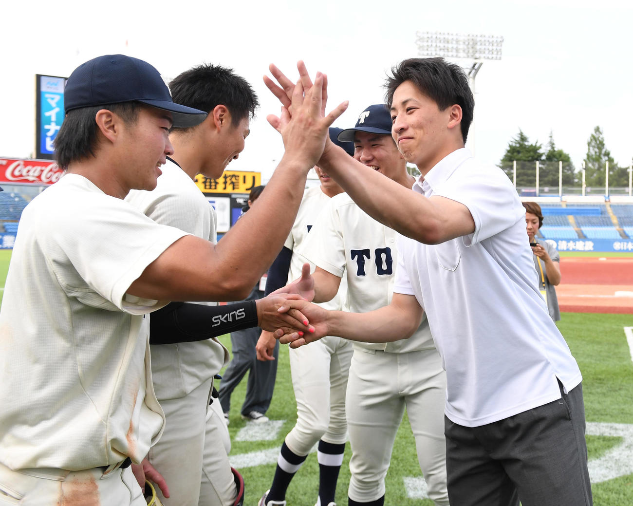 1部昇格が決まりナインとハイタッチする東洋大・細野（右）（撮影・柴田隆二）