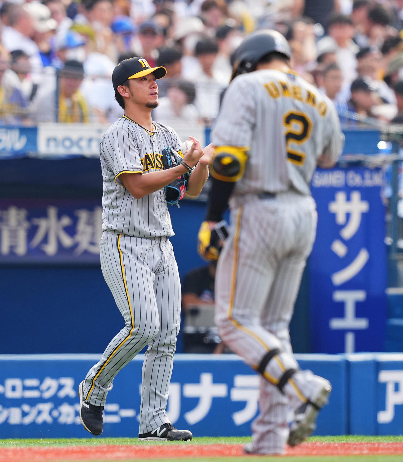 DeNA対阪神　7回表阪神2死一塁、梅野（右）が右飛に倒れ無得点のままマウンドへ向かう伊藤将（撮影・垰建太）