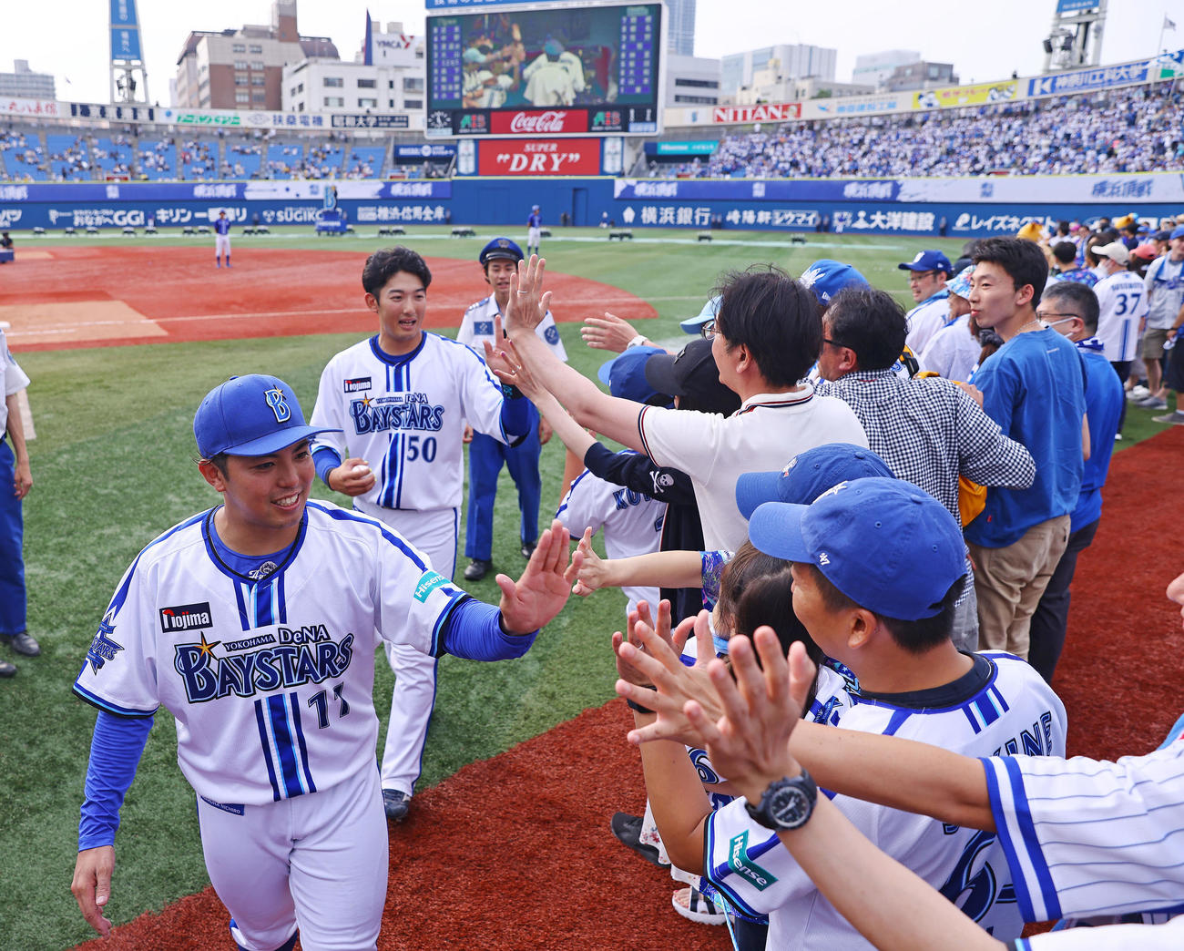 DeNA対阪神　阪神に勝利しファンとタッチするDeNA東（手前）と山本（撮影・垰建太）