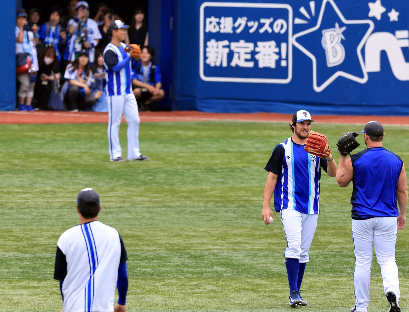 DeNA対阪神　試合前、ファンが見つめる中、キャッチボールを終えて笑顔でグラブタッチするDeNAバウアー（右から2人目）（撮影・浅見桂子）