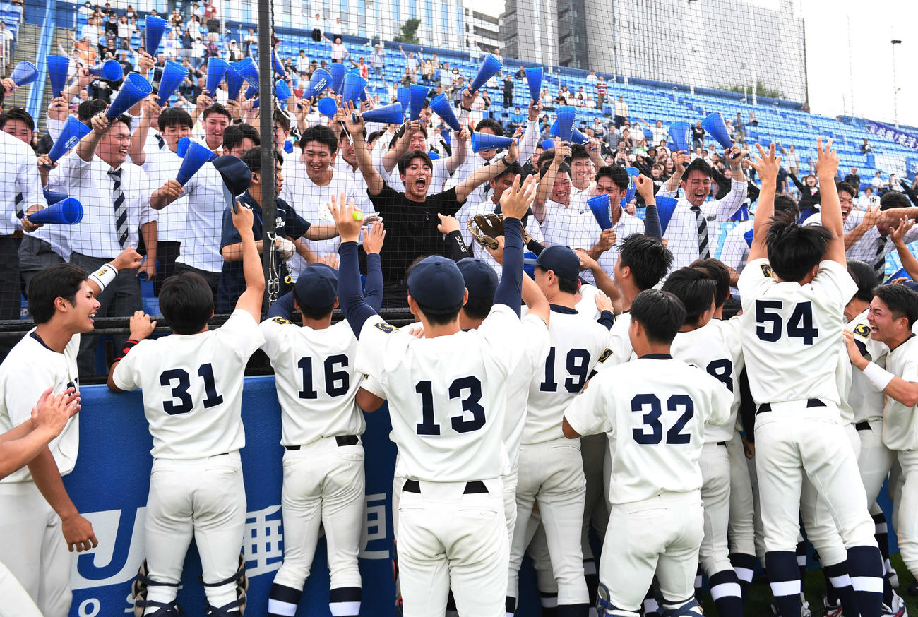 駒大を破り1部昇格を決めた東洋大ナインは応援席の部員と喜び合う（撮影・柴田隆二）