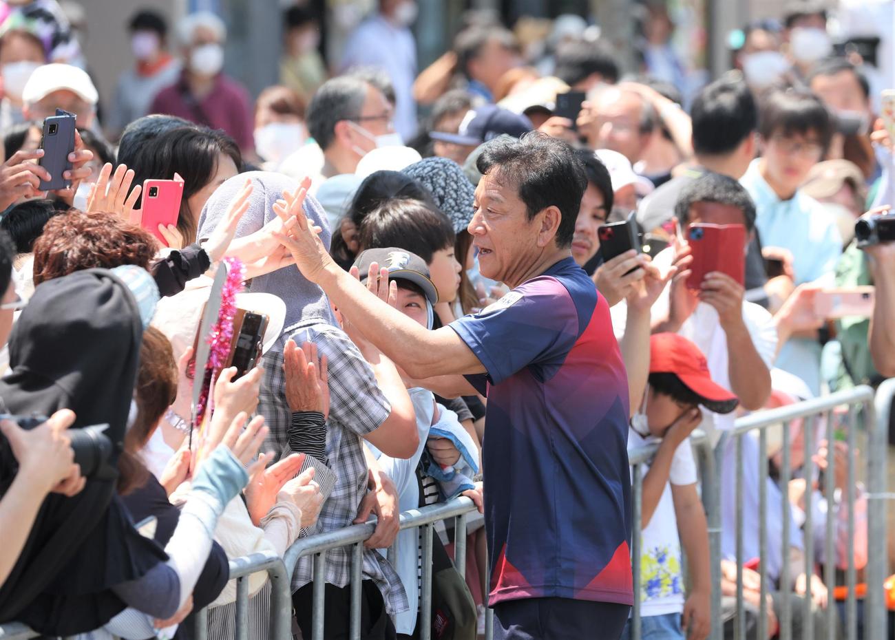 「栗山監督優勝パレード」で沿道の観衆とタッチする侍ジャパン栗山英樹前監督（撮影・黒川智章）