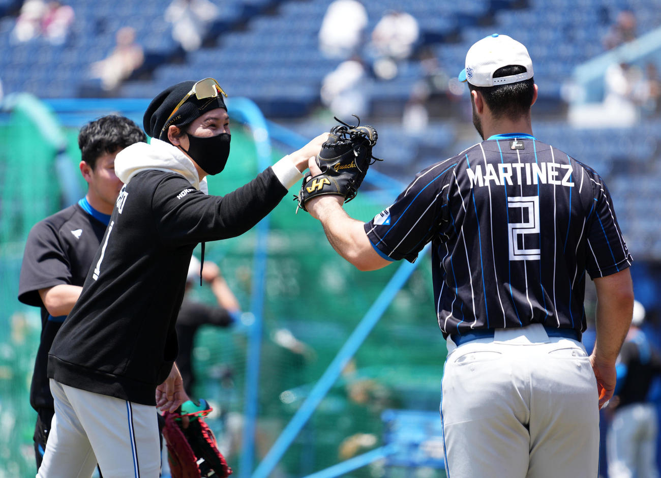 ロッテ対日本ハム　日本ハムマルティネス（右）とタッチを交わす新庄監督（撮影・横山健太）
