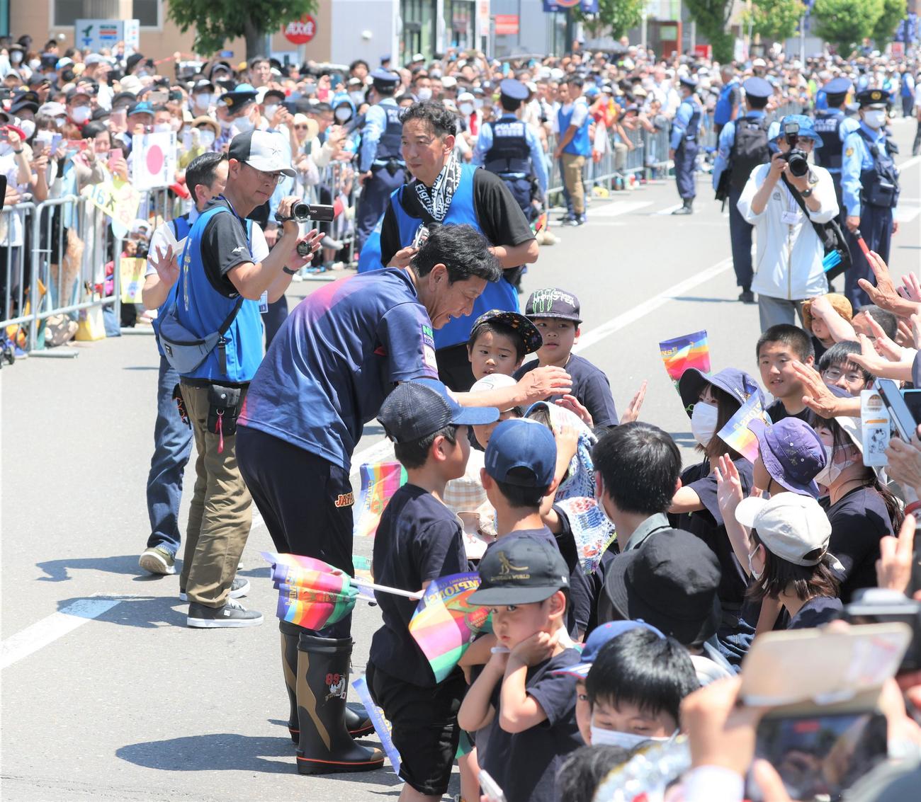 「栗山監督優勝パレード」で沿道の観衆とタッチする侍ジャパン栗山英樹前監督（撮影・黒川智章）