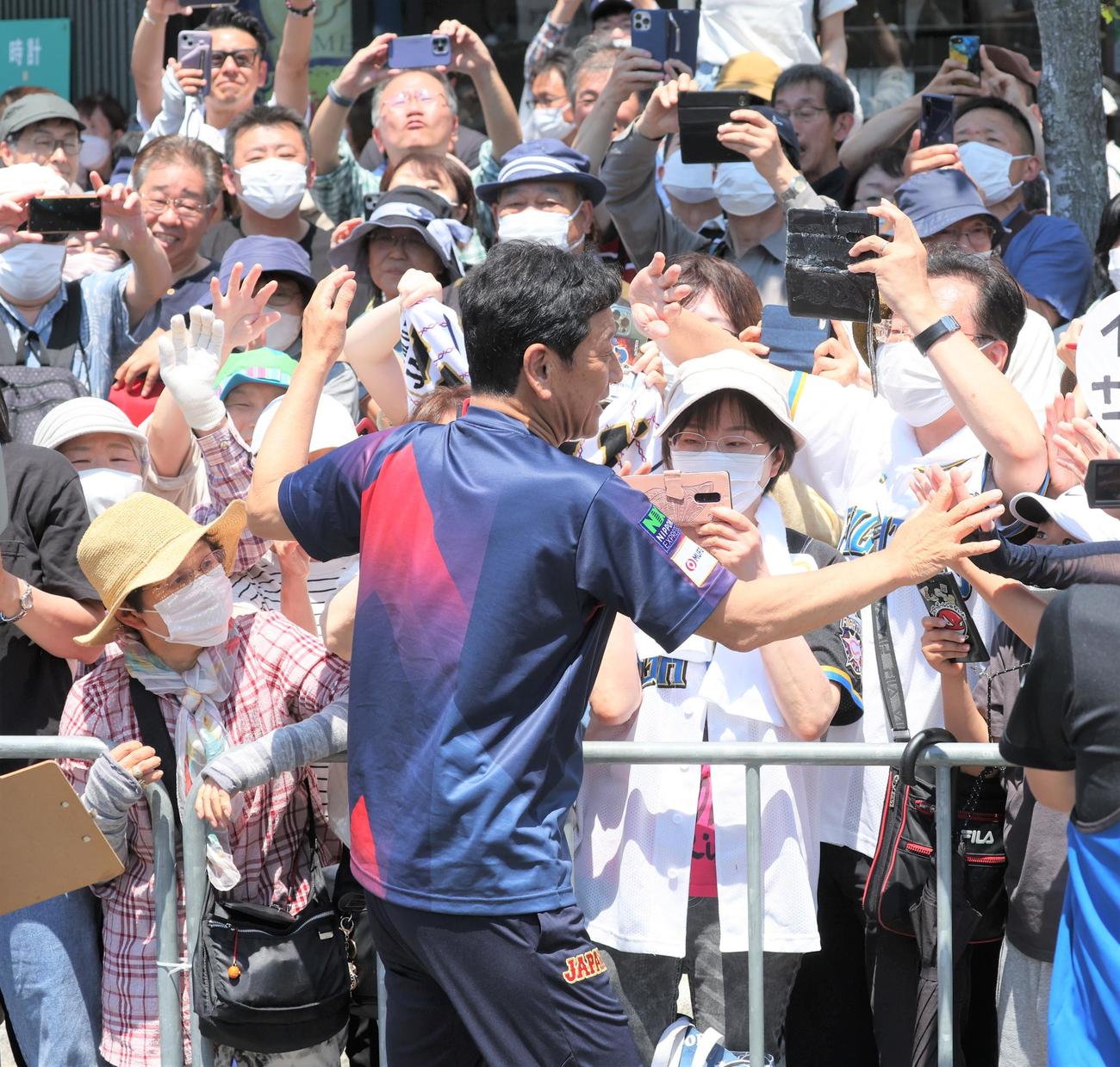 「栗山監督優勝パレード」で沿道の観衆とタッチする侍ジャパン栗山英樹前監督（撮影・黒川智章）
