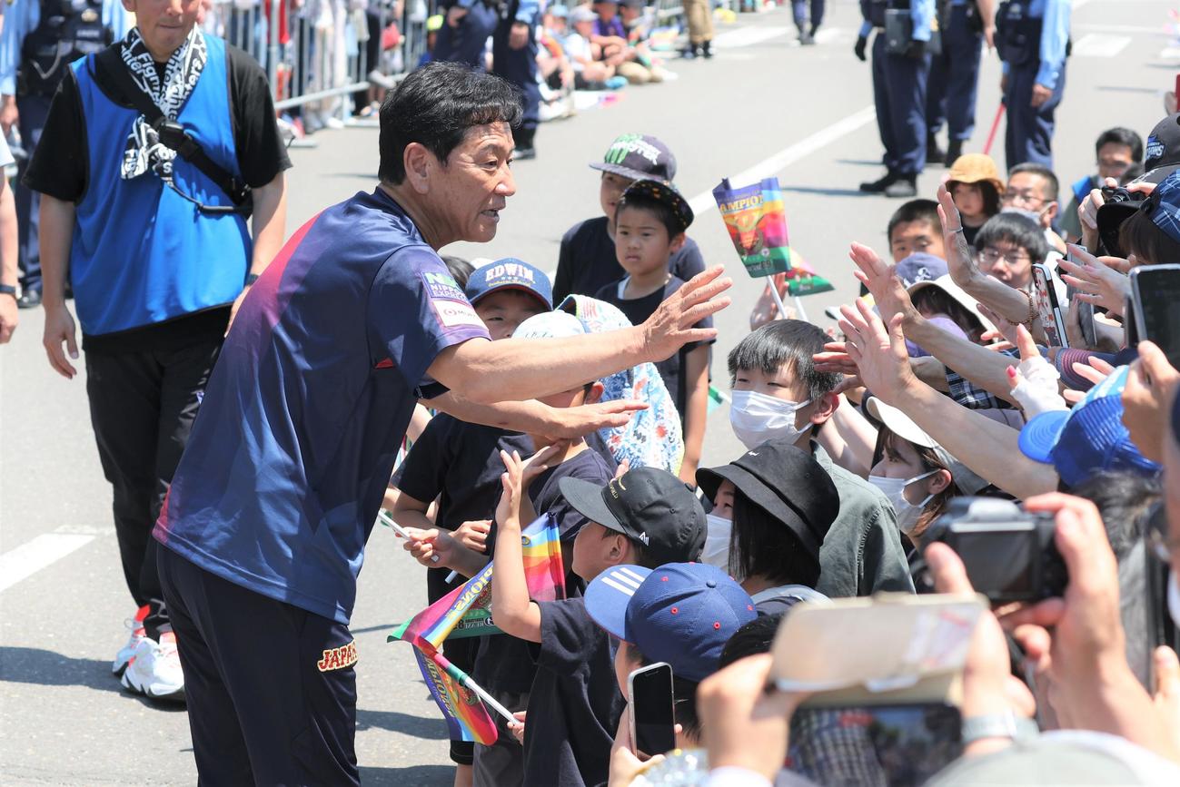 「栗山監督優勝パレード」で沿道の観衆とタッチする侍ジャパン栗山英樹前監督（撮影・黒川智章）