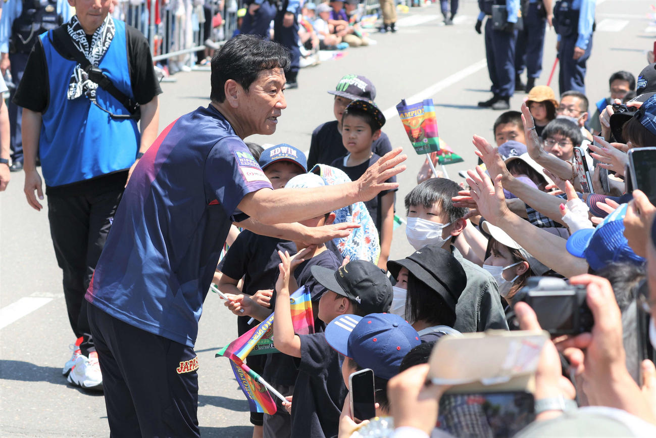 「栗山監督優勝パレード」で沿道の観衆とタッチする侍ジャパン栗山英樹前監督（撮影・黒川智章）
