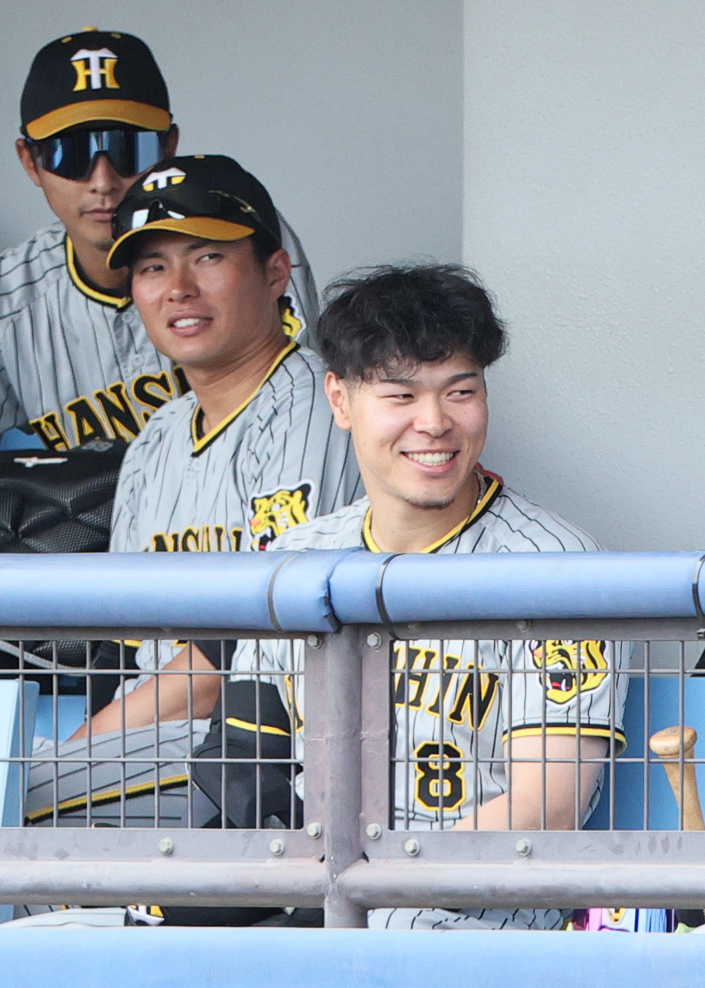 ウエスタン・リーグ中日対阪神　阪神佐藤輝（手前）はベンチでリラックスした表情を見せる（撮影・上山淳一）