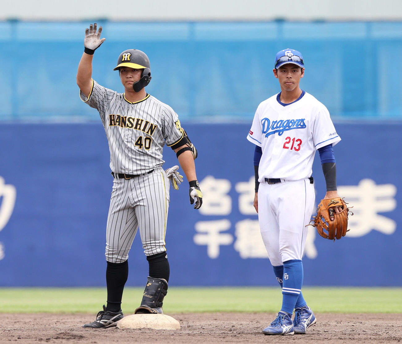 4回表阪神1死一塁、二塁打を放った井坪（左）はベンチの祝福に手を挙げる（撮影・上山淳一）
