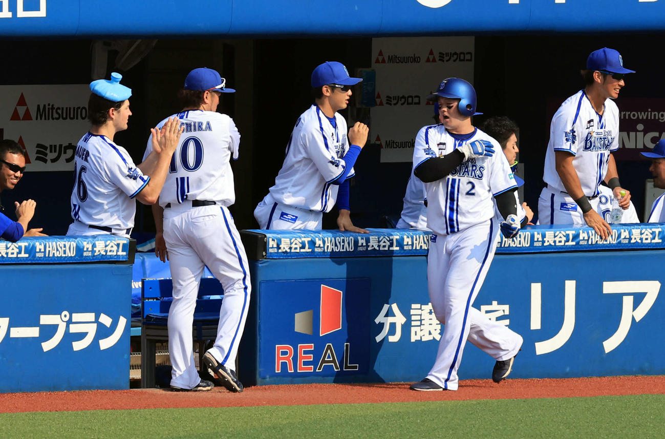 DeNA対阪神　5回裏DeNA2死二塁、宮崎の中越え適時二塁打で生還した牧は氷〓（古とウカンムリを縦に並べて縦棒を貫き、下に襄のナベブタを取る）（ひょうのう）を頭に乗せたバウアー（左）らとハイタッチ（撮影・浅見桂子）