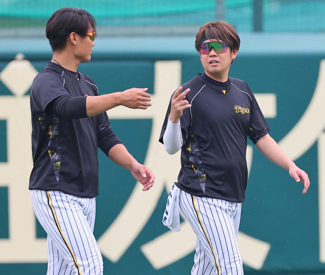西純（左）と話をする西勇（撮影・上田博志）