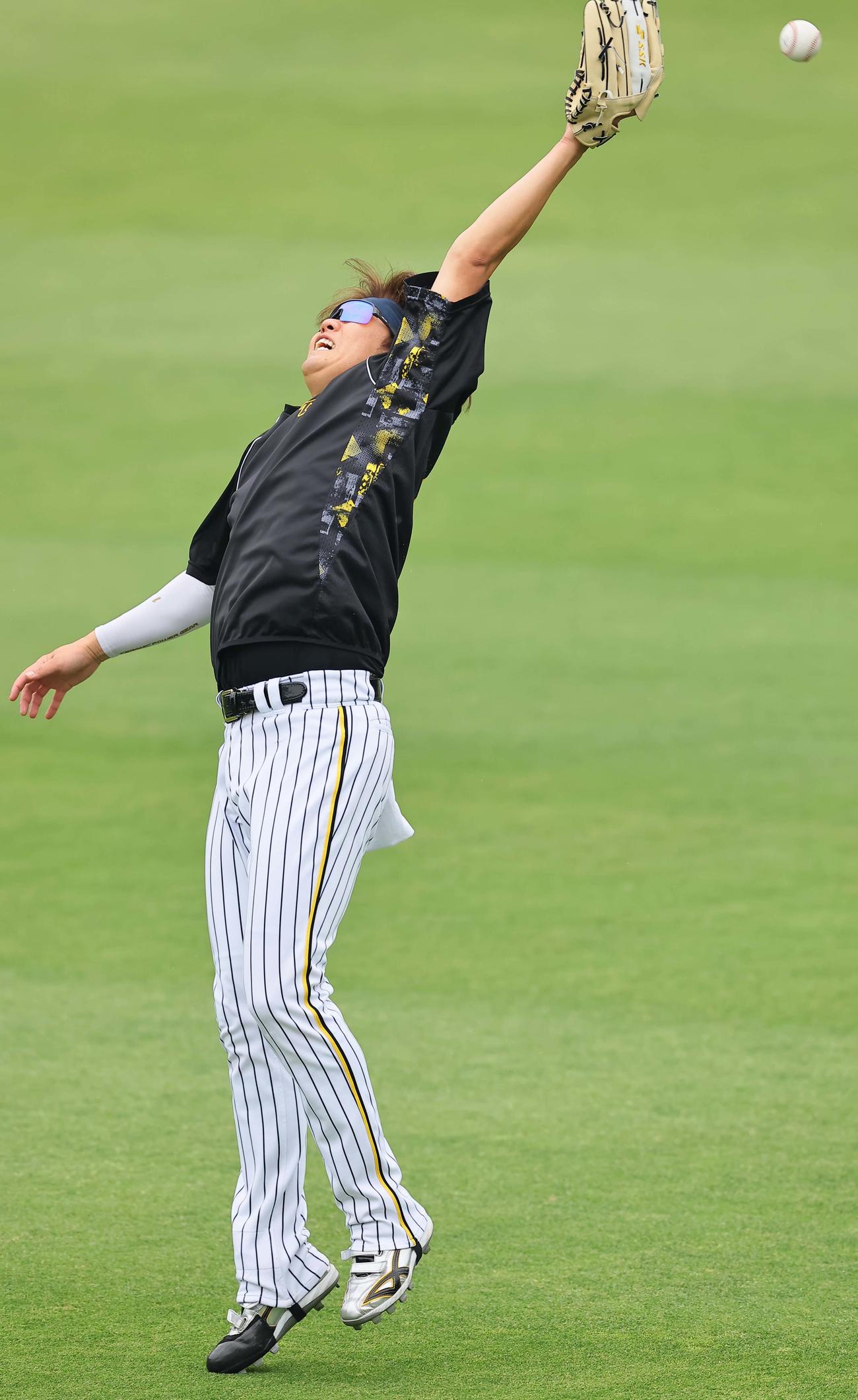 キャッチボールをする西勇は高めのボールにグラブを伸ばす（撮影・上田博志）