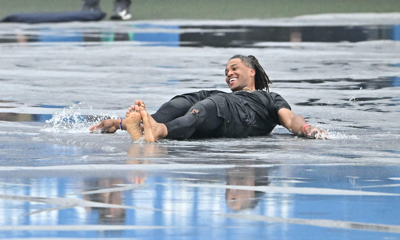 巨人対ヤクルト　雨天中止となり雨水のたまったシートにヘッドスライディングを決め笑顔の巨人ウォーカー（撮影・滝沢徹郎）