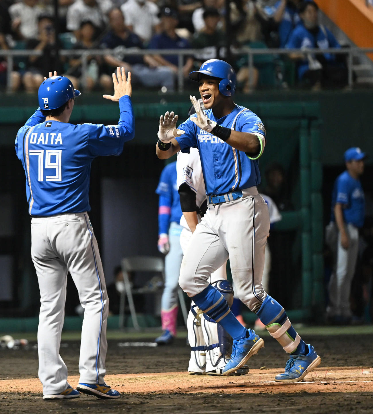 西武対日本ハム　7回表日本ハム無死一塁、2点本塁打を放った万波（右）は代田コーチとタッチを交わす（撮影・山崎安昭）