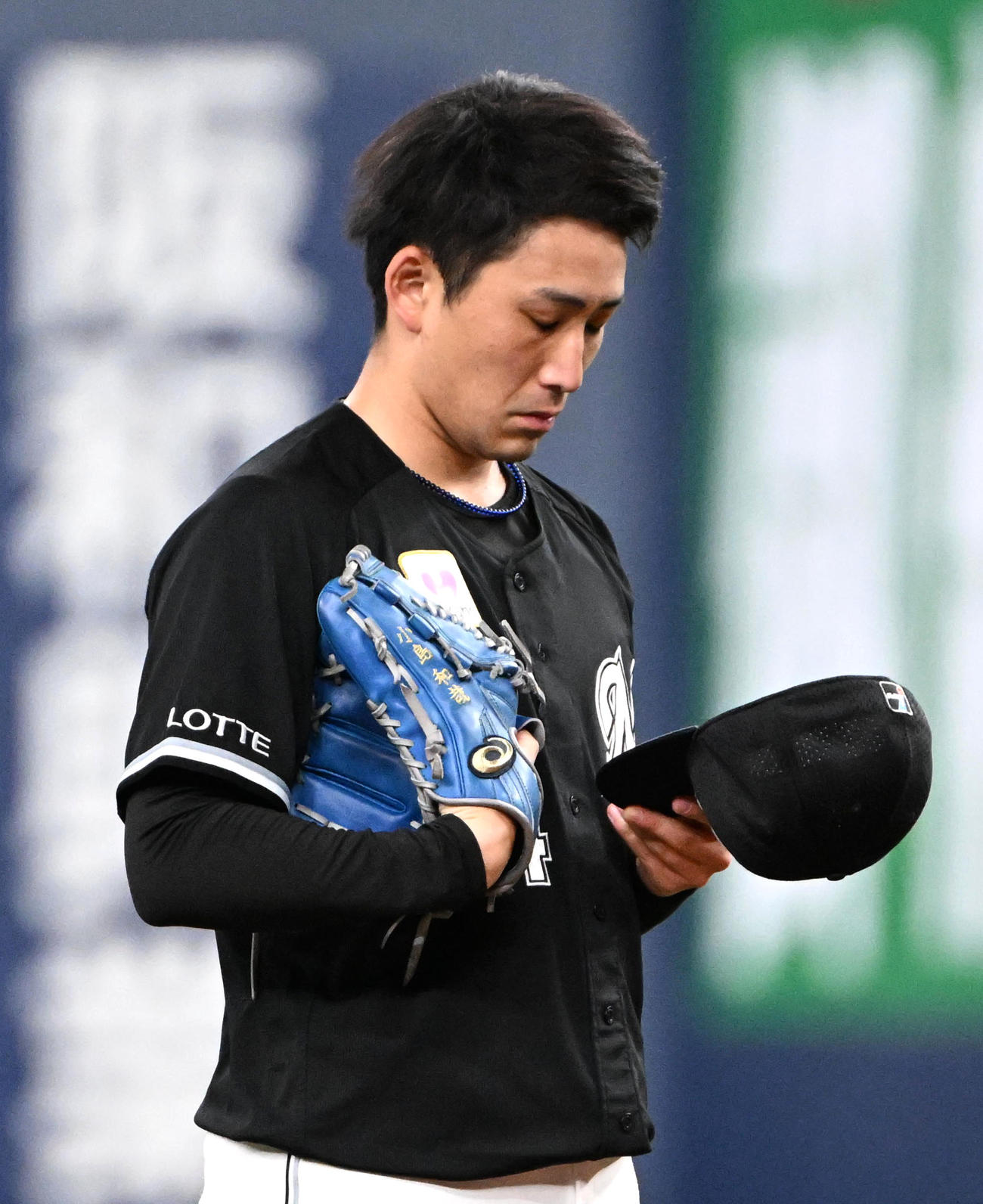 オリックス対ロッテ　4回裏、投球前に帽子を見つめる小島（撮影・石井愛子）