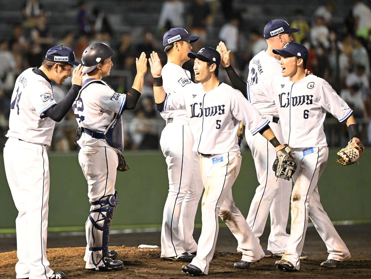 西武対日本ハム　タッチを交わして勝利を喜ぶ外崎（右から3人目）源田（右）ら西武の選手たち（撮影・山崎安昭）